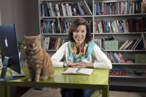 Susan Micari at her desk, with her cat